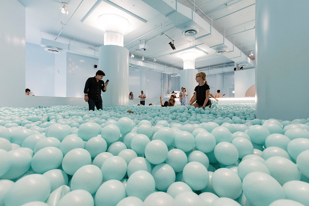 people playing in the baby blue ball pit at the color factory nyc